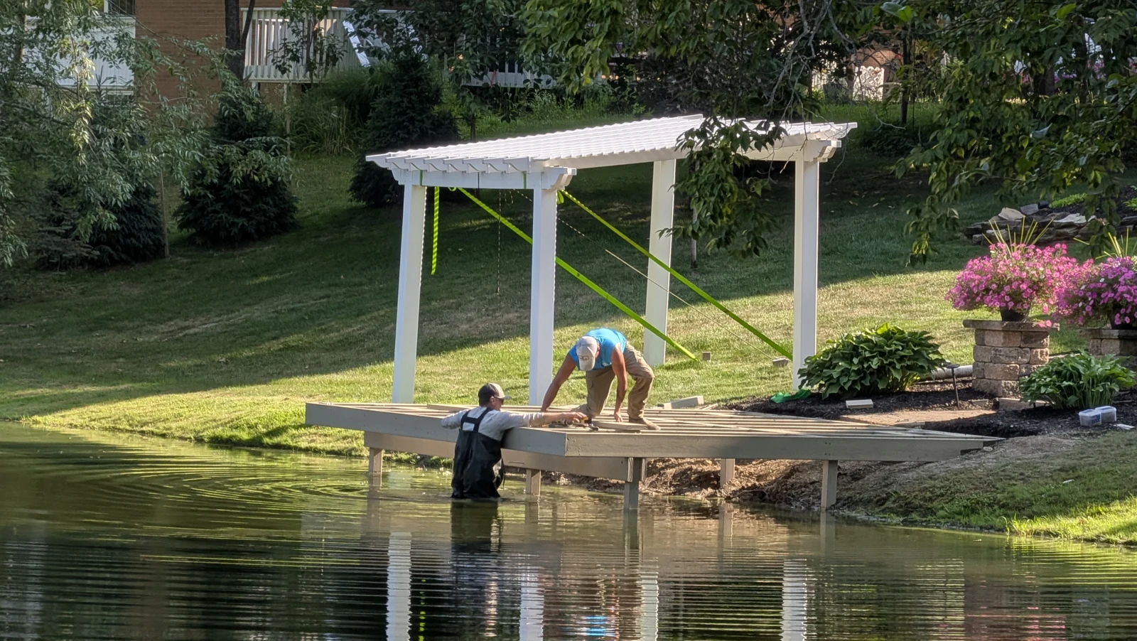 AquaLife crew assembling a dock frame at the shoreline
