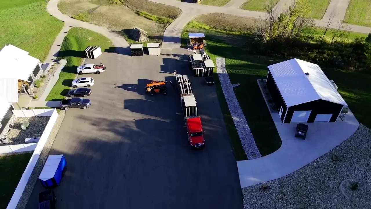 Aerial video still showing the delivery truck, stacked dock sections and equipment at the venue.