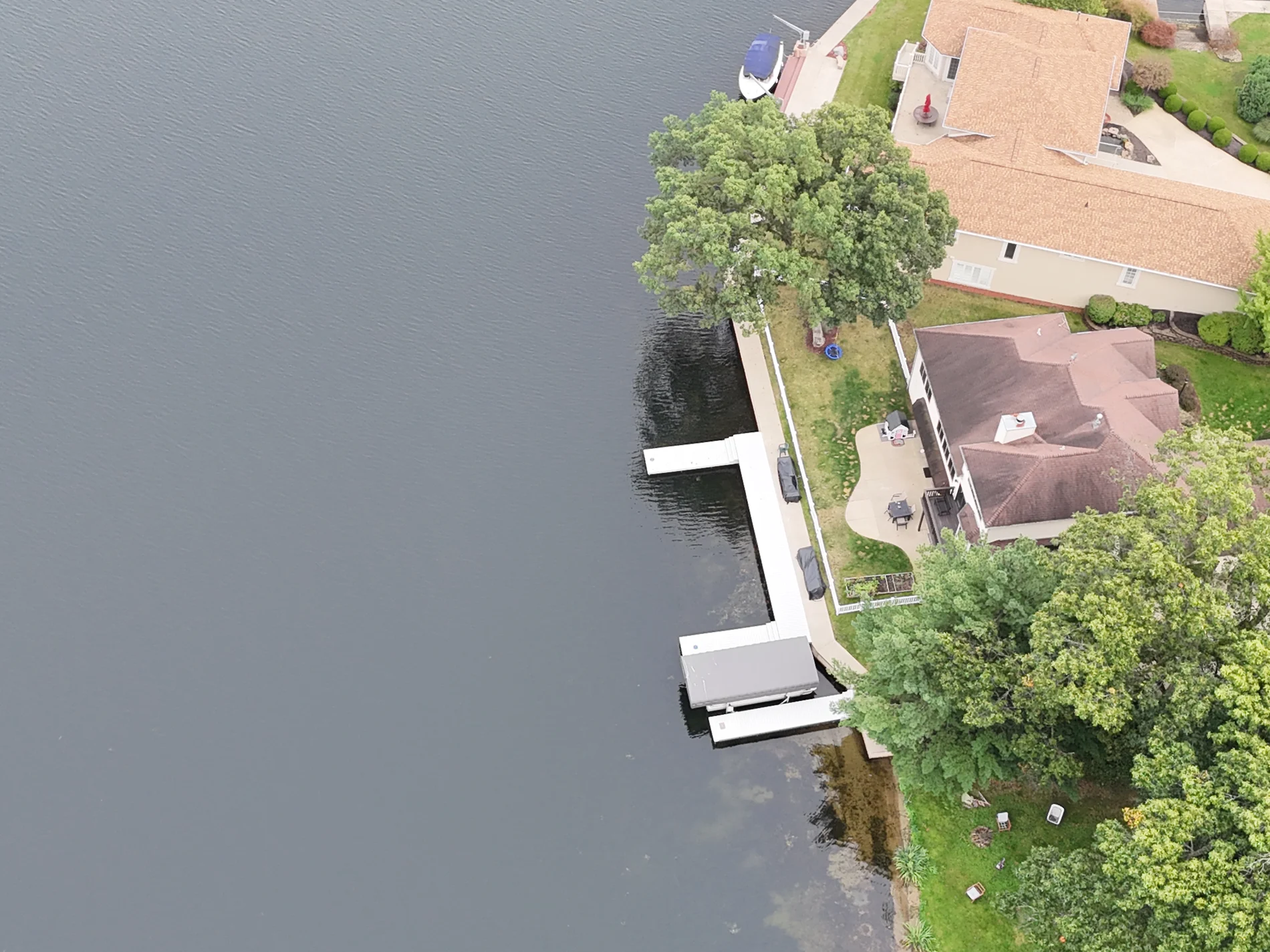 An aerial view of the white shoreline dock and projecting boat-access sections at the property.