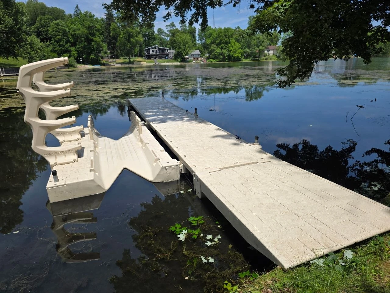 Wave Armor kayak launch connected beside a floating dock, with a kayak storage rack overlooking the lake.