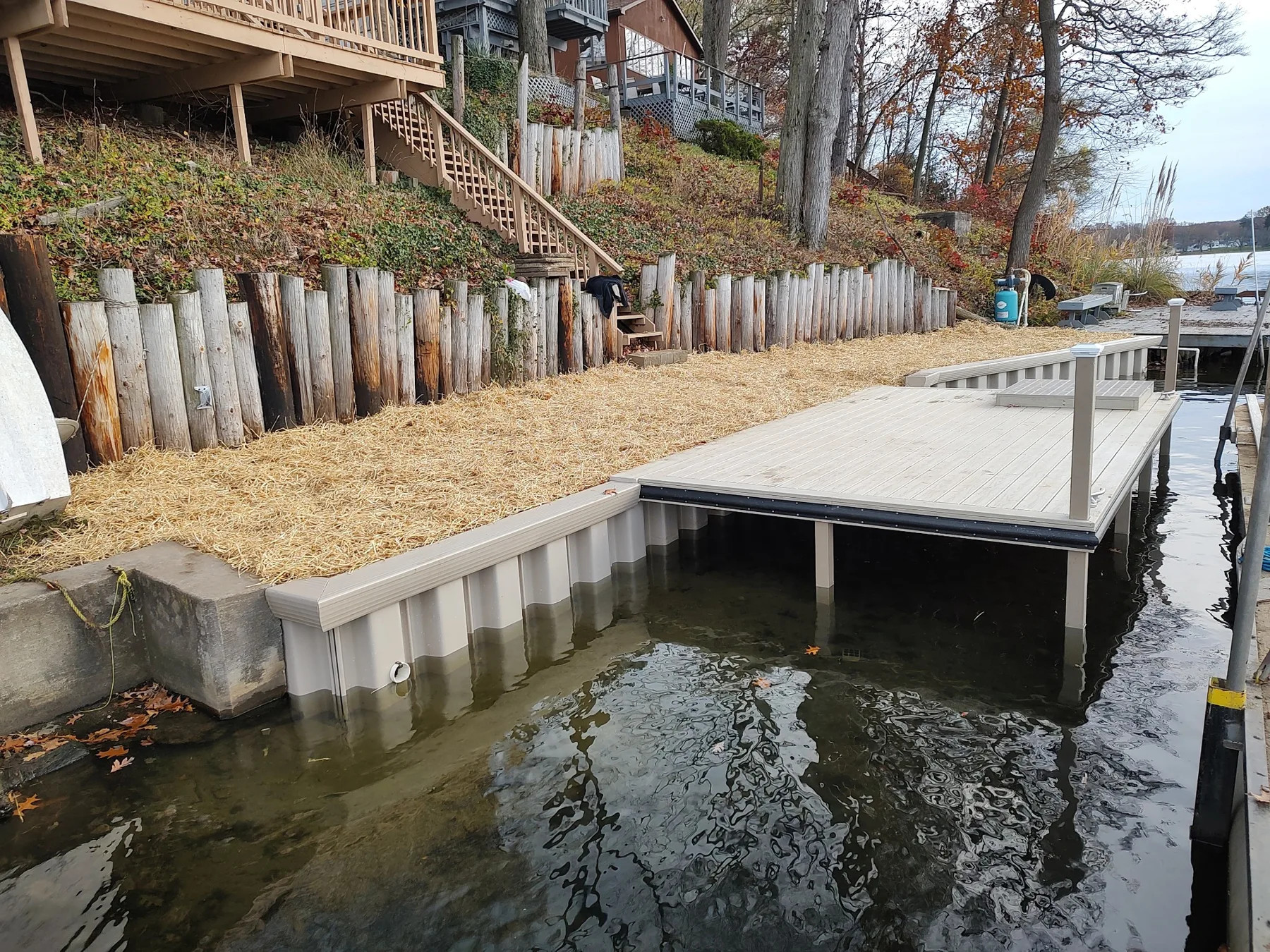 The capped seawall and dock beside the restored, straw-covered bank on Long Lake.