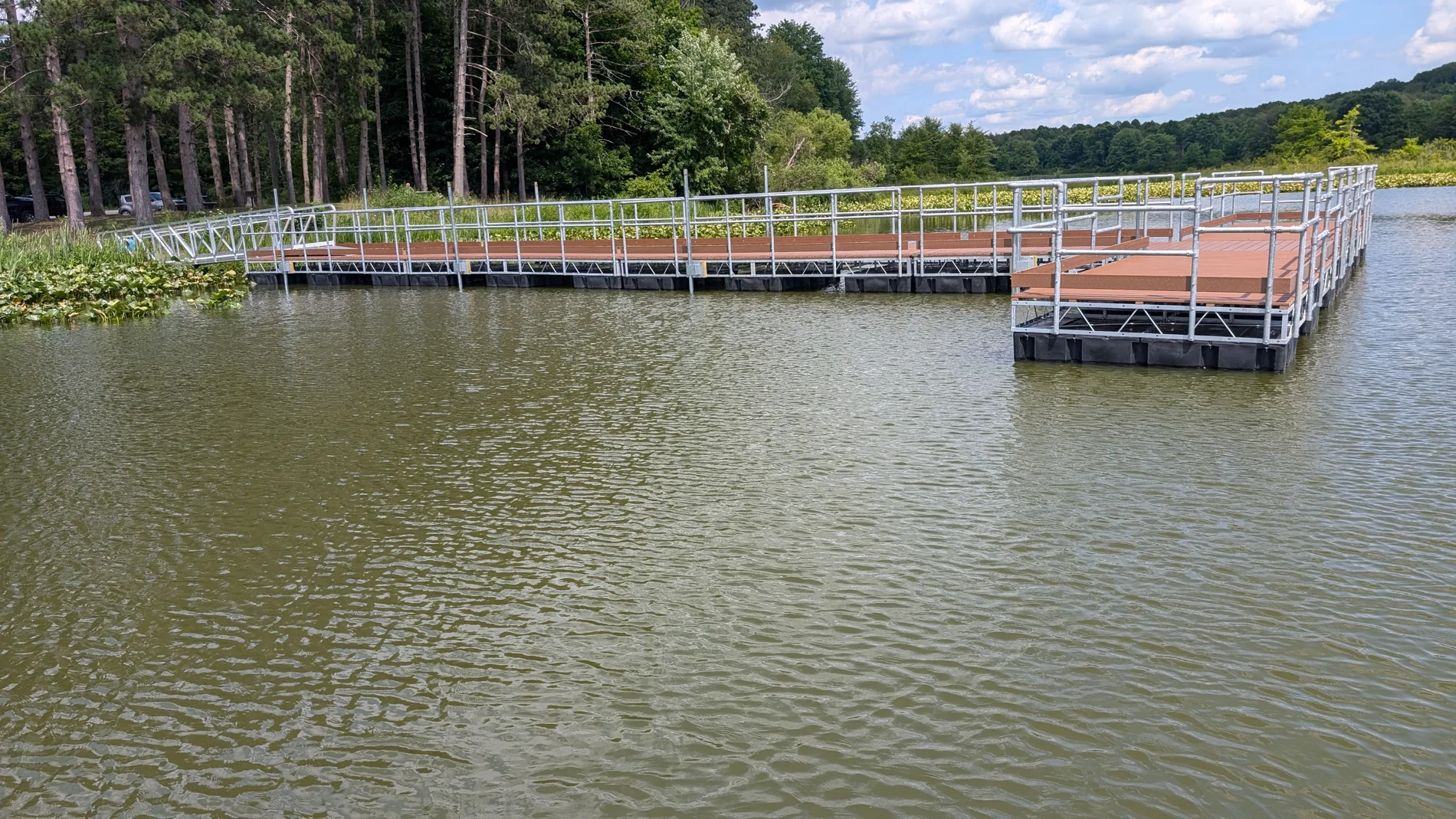 The long gangway and railed floating fishing platform viewed from the reservoir.