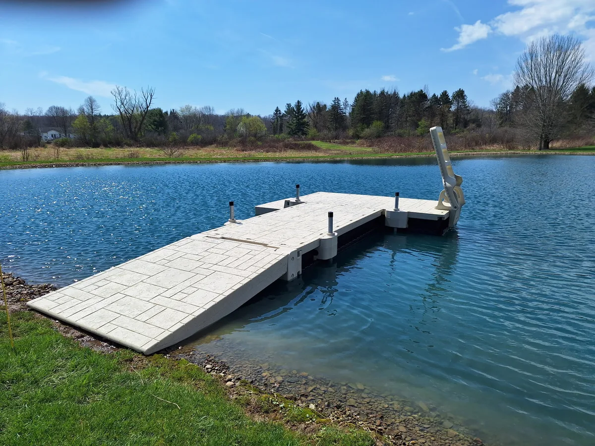 Wave Armor floating pond dock with a wide shoreline entry ramp and open gathering platform