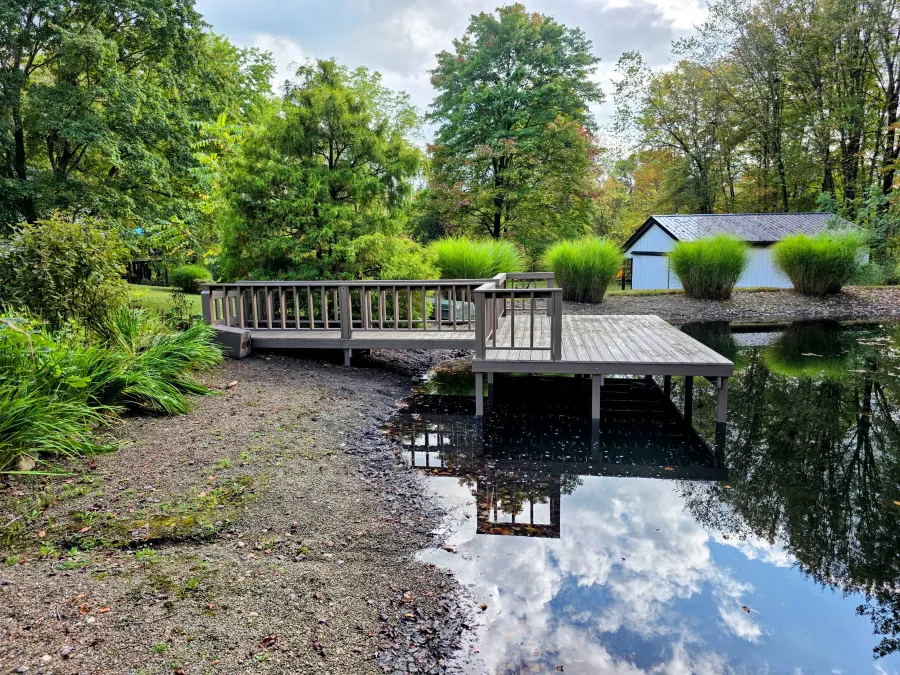 Finished pond dock with a railed walkway and entrance gate