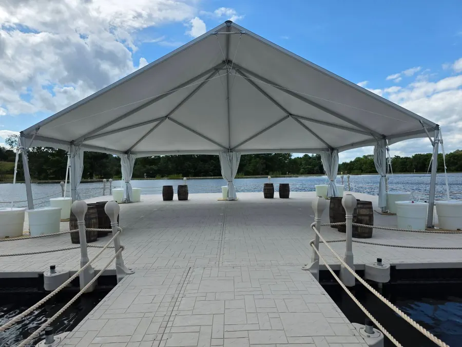 Rope-lined approach to the floating event pavilion beneath a white tent