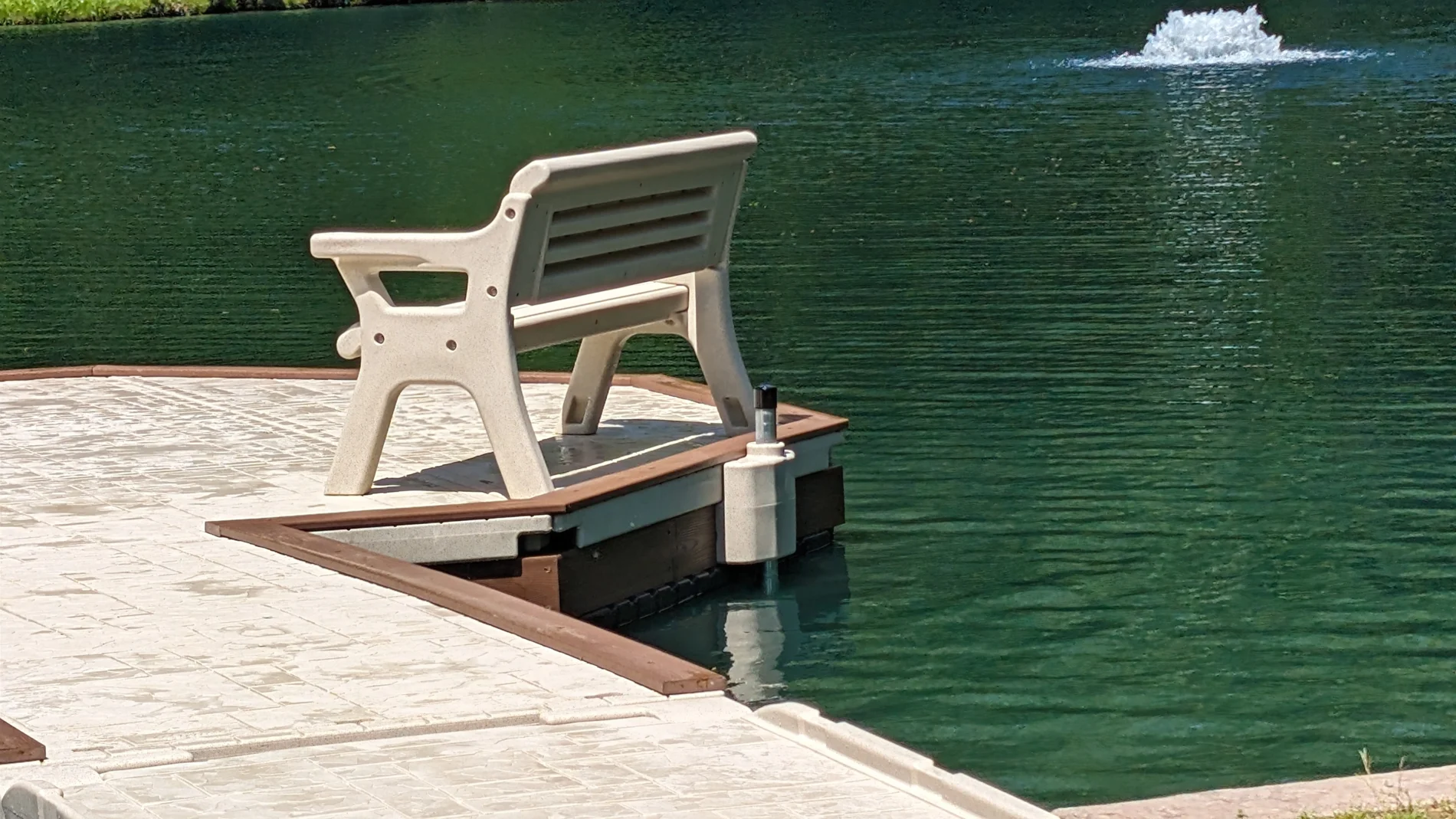A bench on the corner of the dock overlooks the pond.