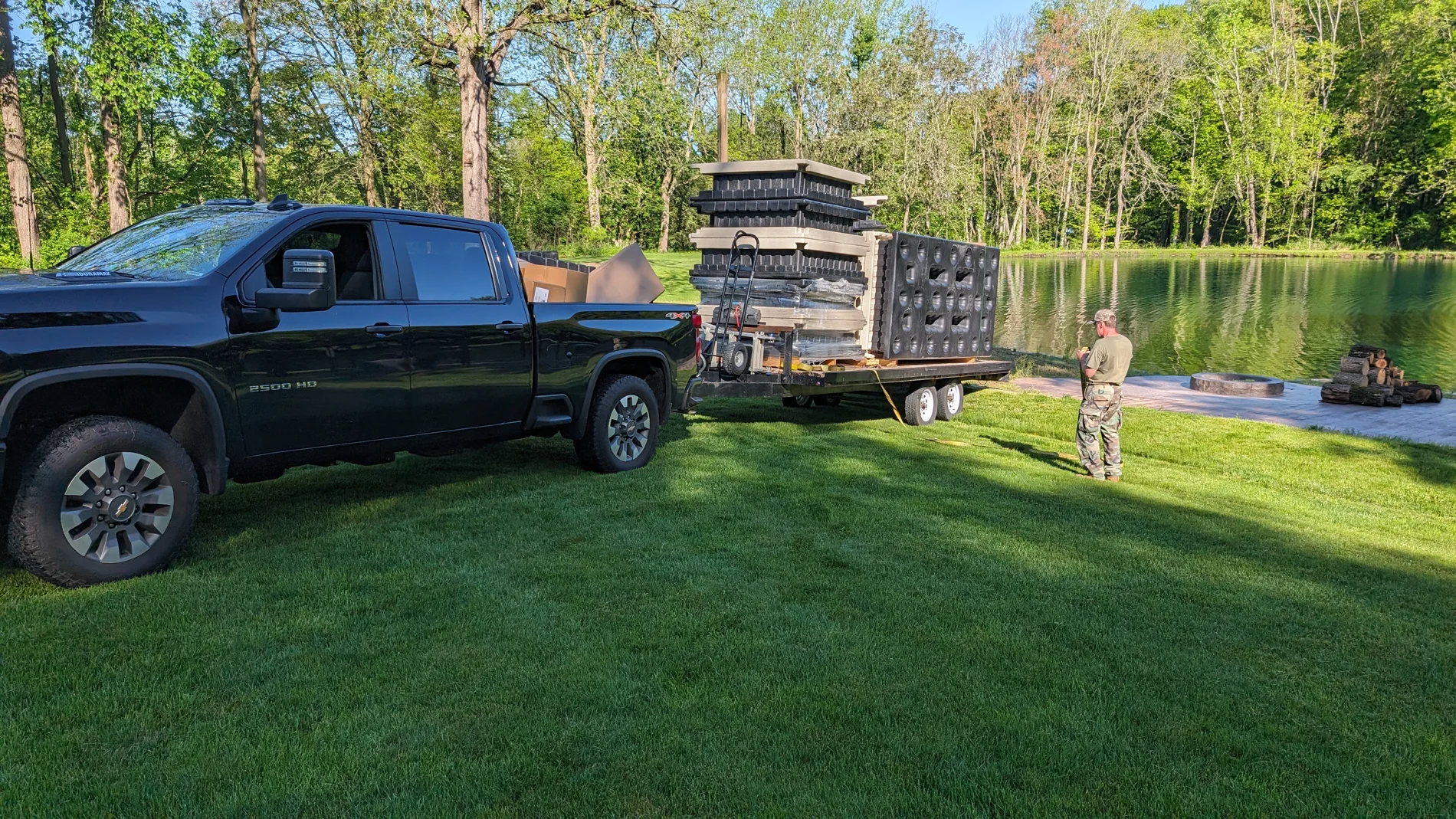 Dock components arrive by trailer beside the private pond.