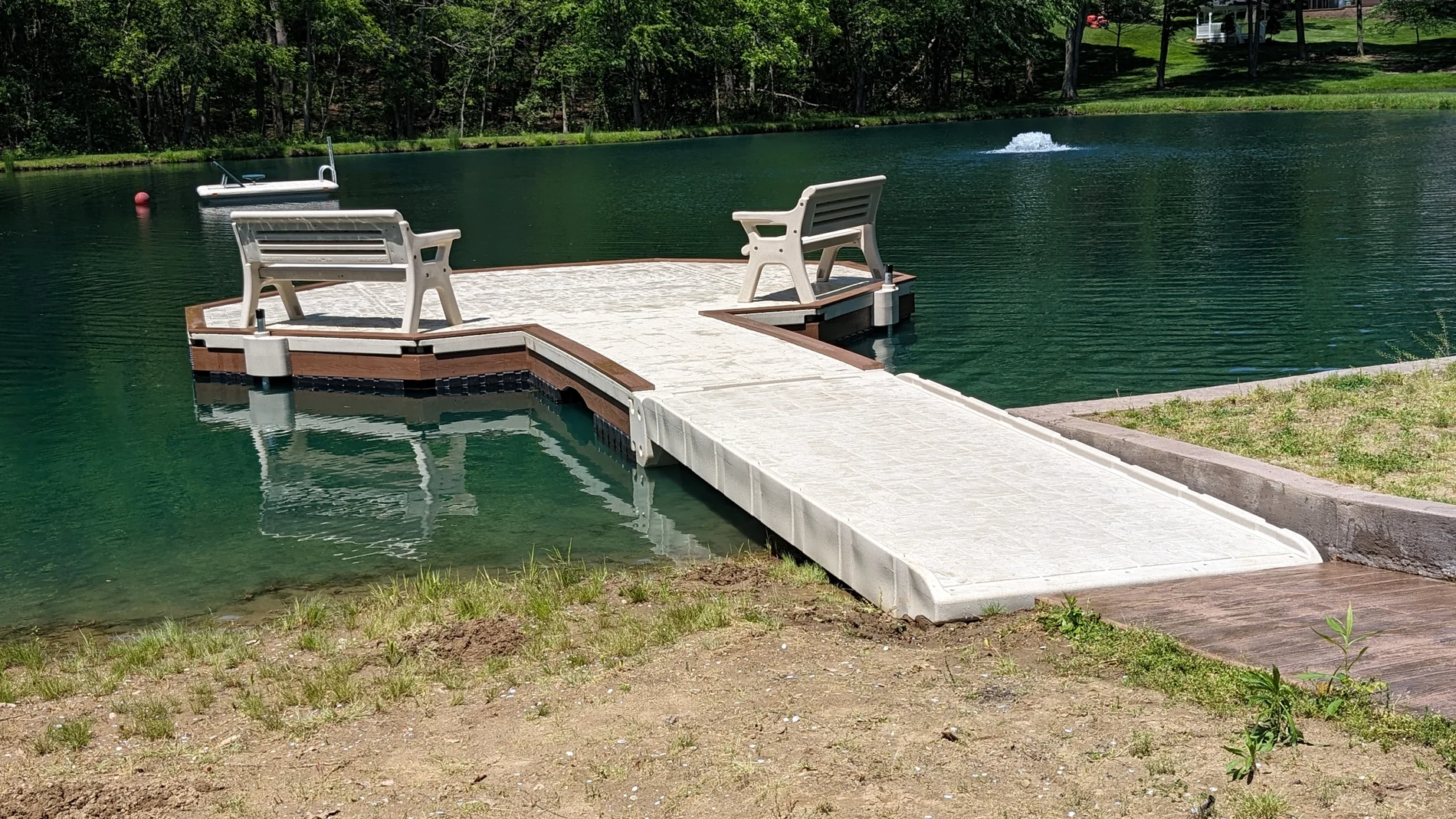 WearDeck and Wave Armor floating dock with two benches at a private pond in Canal Fulton.