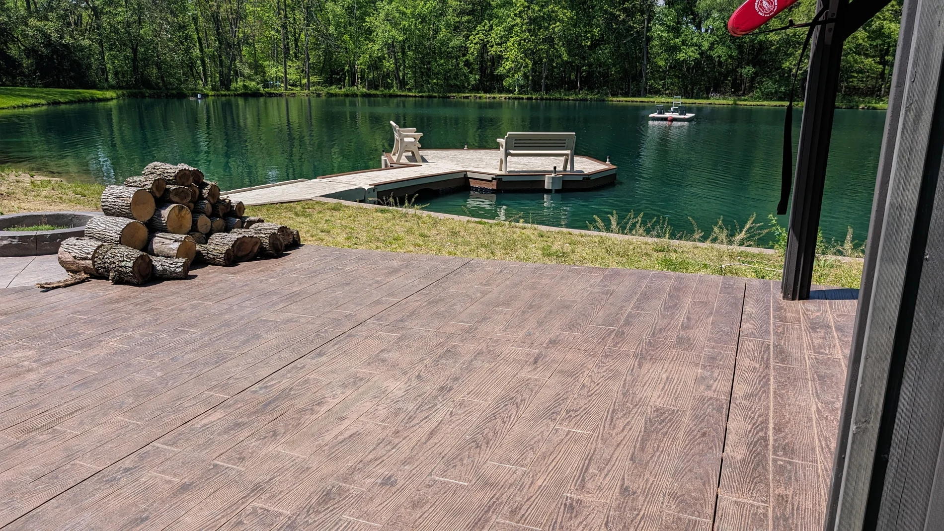 View from the existing patio toward the dock and wooded pond.