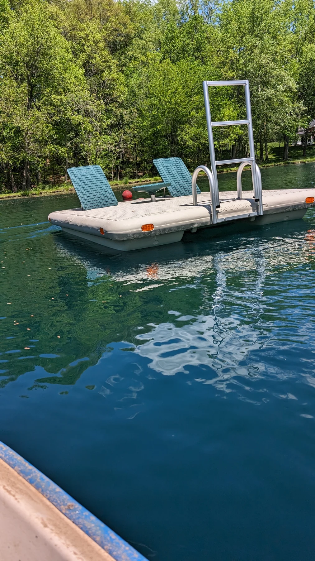Island swim raft with two backrests, a central table and an aluminum ladder on a private pond