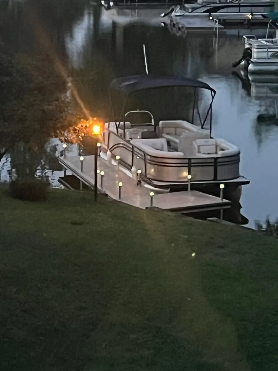 Solar post lights illuminate the dock edges in the evening.