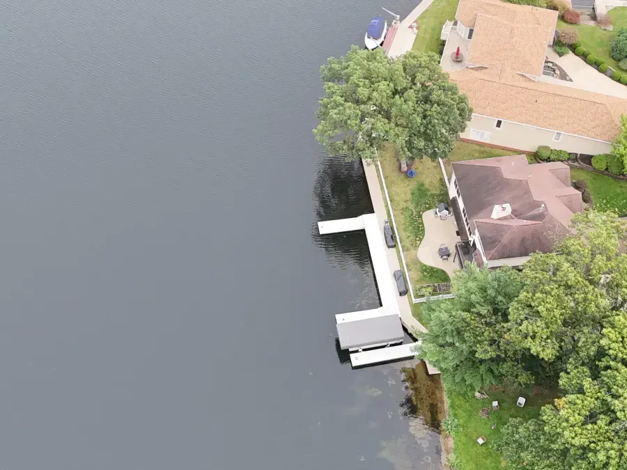 White custom dock following the shoreline with projecting boat-access sections