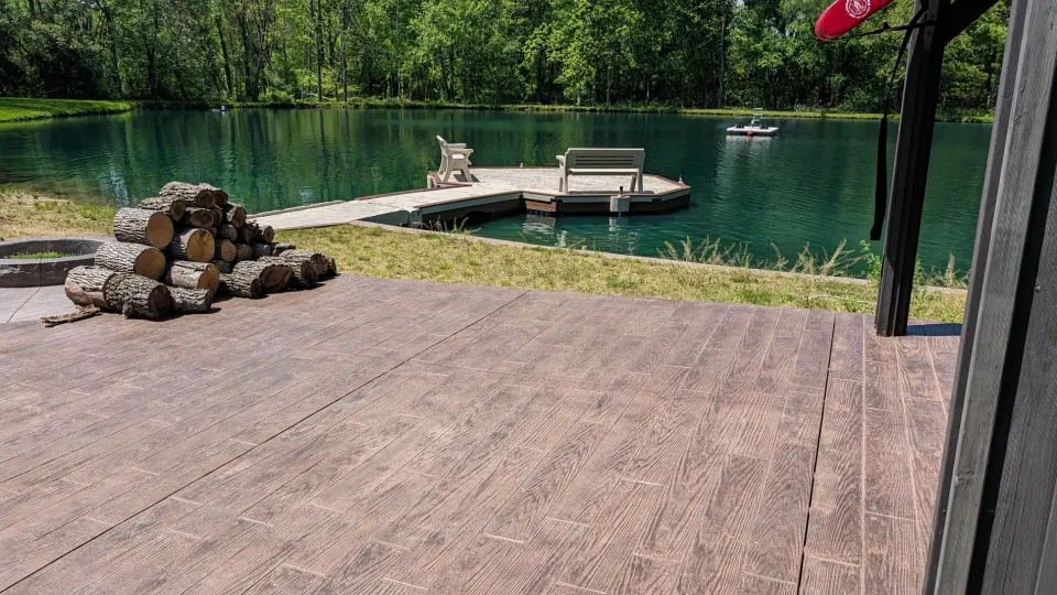 View from the existing patio toward the dock and wooded pond.