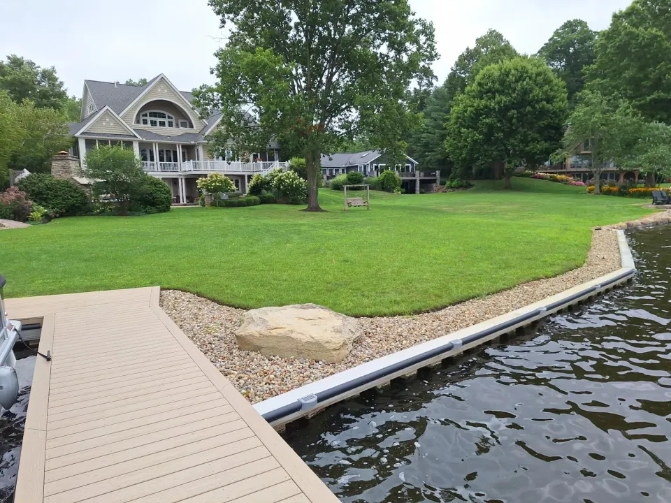 Dock meeting the curved seawall and stone-lined lawn at Congress Lake