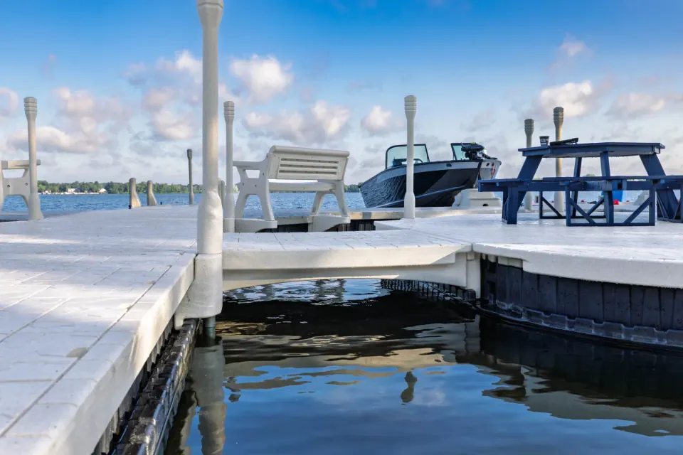Connected Wave Armor floating dock sections with a corner platform, dock posts, and seating beside the water