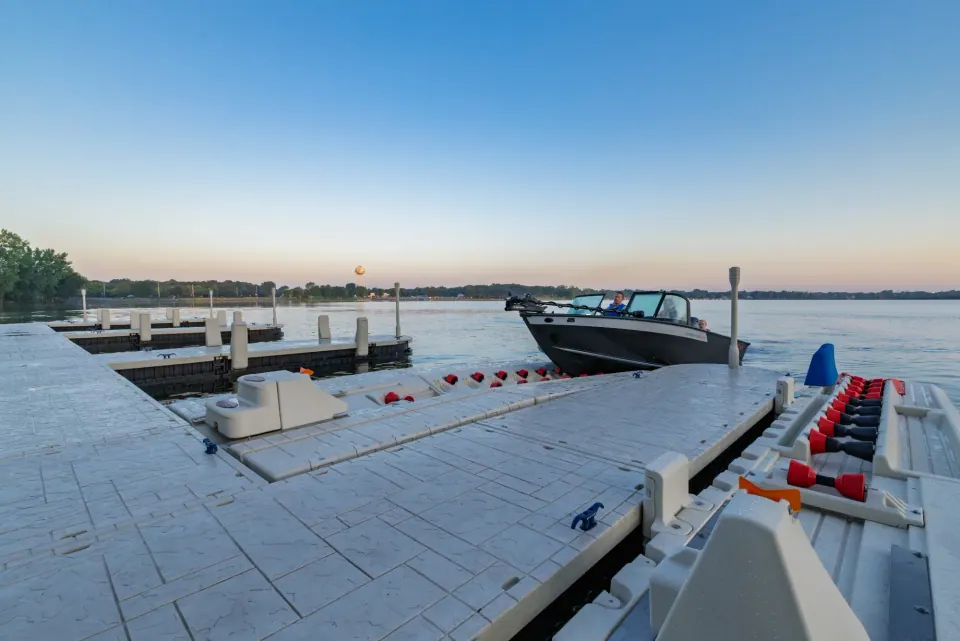 Wave Armor floating dock with a boat and PWC ports on the water at sunset