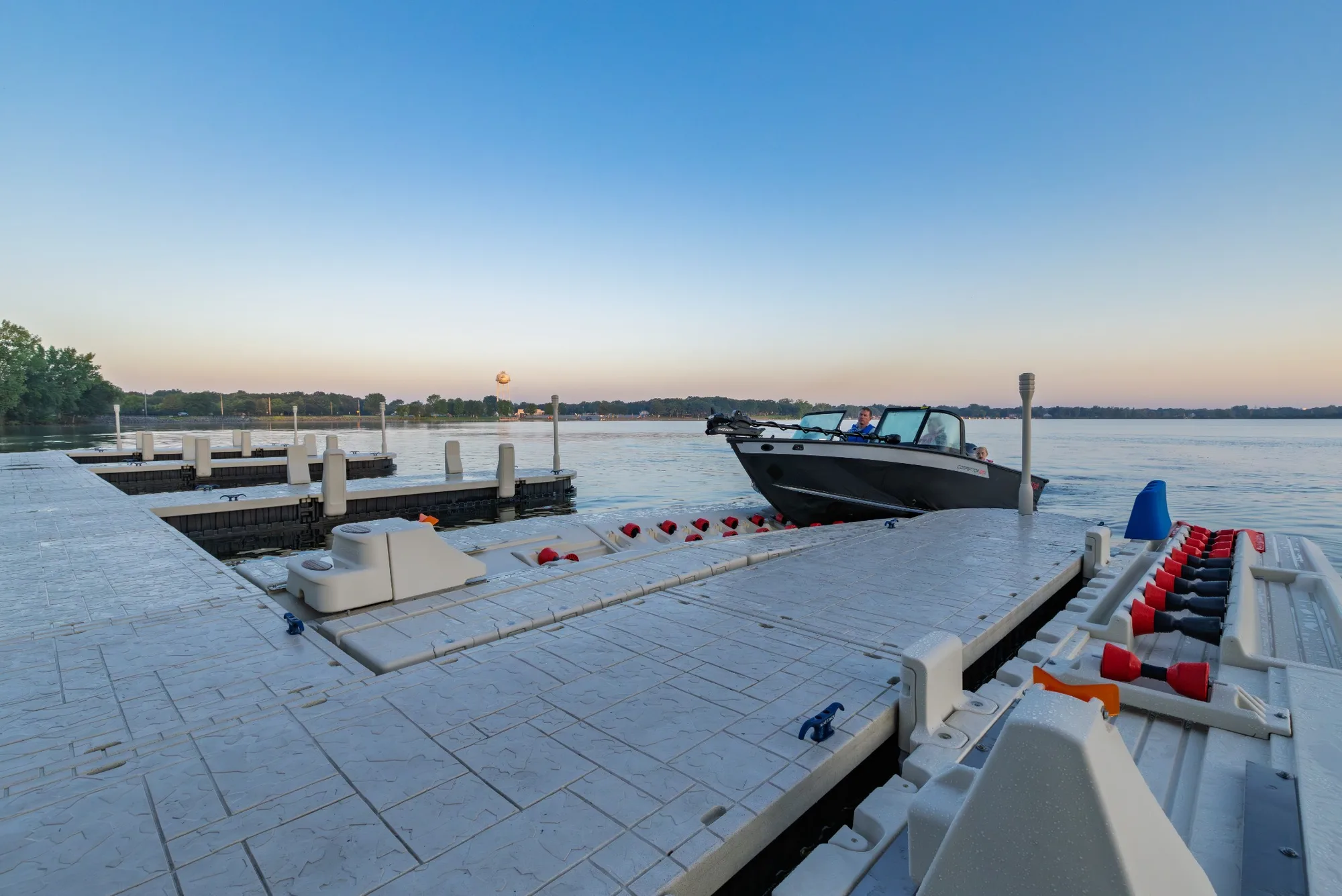 Wave Armor floating dock with a boat and PWC ports on the water at sunset